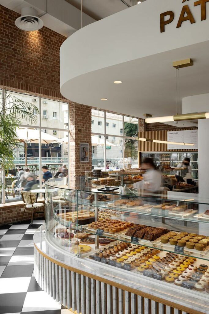 Vitrine de pâtisserie moderne avec assortiment de gâteaux, tartes et viennoiseries dans une boutique élégante