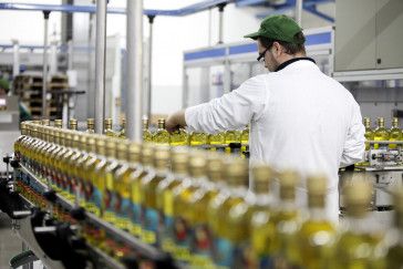 Chaîne de production industrielle avec opérateur contrôlant l’embouteillage de bouteilles d’huile