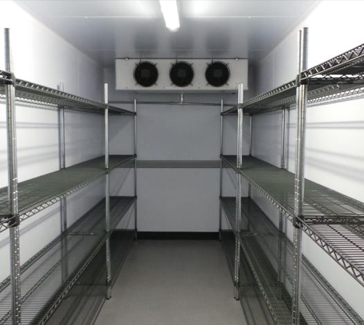 Chambre froide professionnelle avec étagères métalliques de stockage et groupe frigorifique