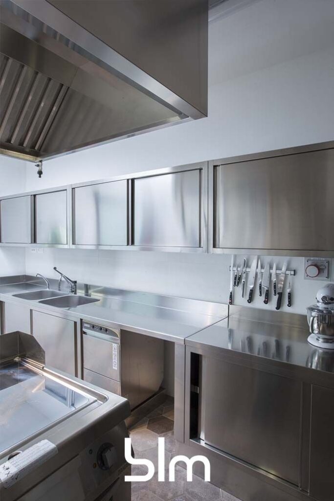 Cuisine professionnelle en inox équipée de plans de travail, éviers et rangements pour restauration