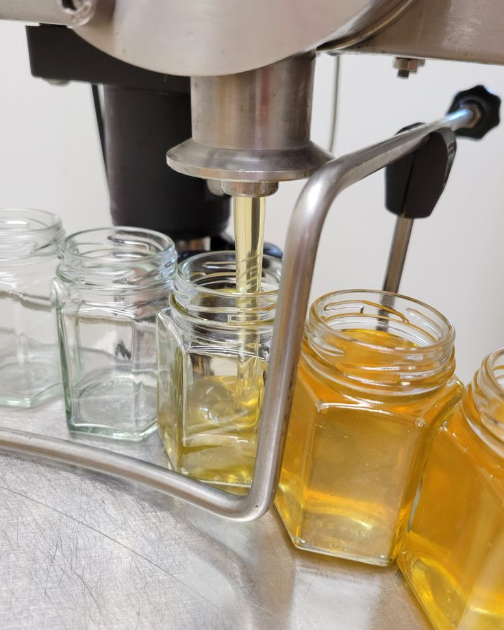 Remplissage de pots en verre avec du miel liquide à l’aide d’une machine de conditionnement apicole