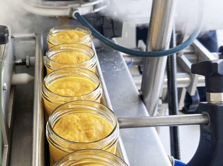Ligne de production agroalimentaire avec remplissage automatique de pots en verre de purée ou soupe de légumes