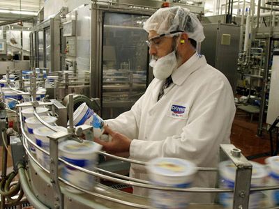 Contrôle qualité sur chaîne de production agroalimentaire avec pots de yaourt en usine